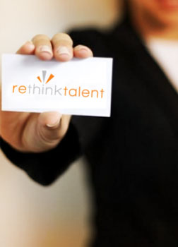 Woman holding business card with Rethink Talent logo